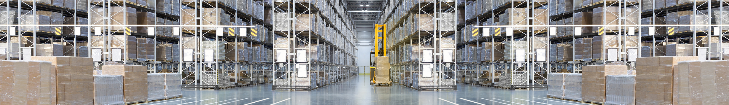 Huge distribution warehouse with high shelves and forklift
